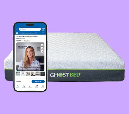 A GhostBed mattress is displayed against a solid purple background, featuring a textured white top and dark base with a green accent stripe. The GhostBed name is clearly visible on the mattress side. In front of it, a smartphone screen shows an online product page for a GhostBed Medium Hybrid Mattress, including a video thumbnail of a woman and several product thumbnails. The composition highlights digital shopping for mattresses and a clean, modern aesthetic.